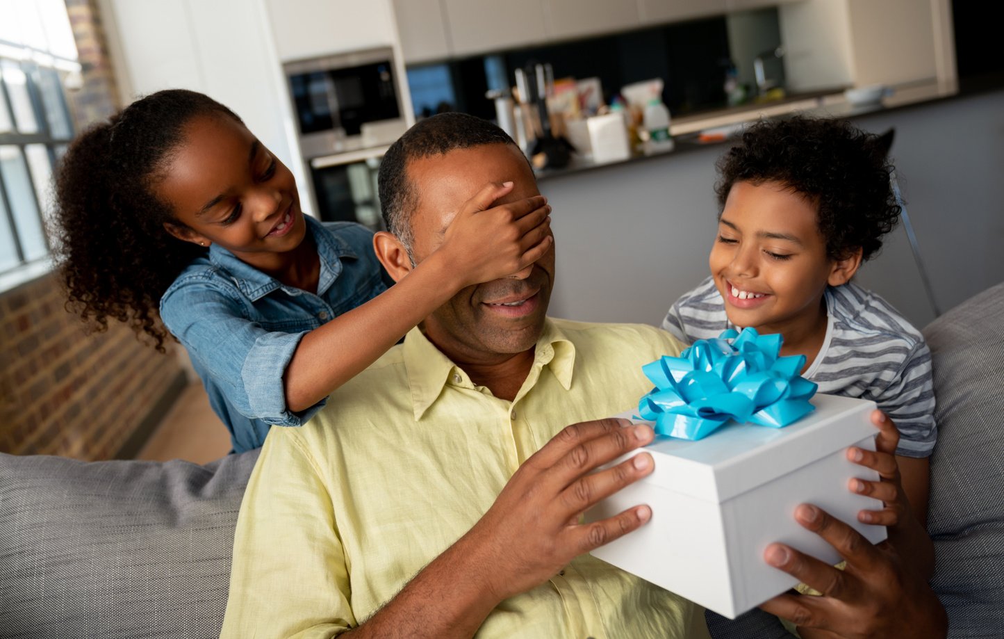 Kids surprising their father with a gift for Father's Day